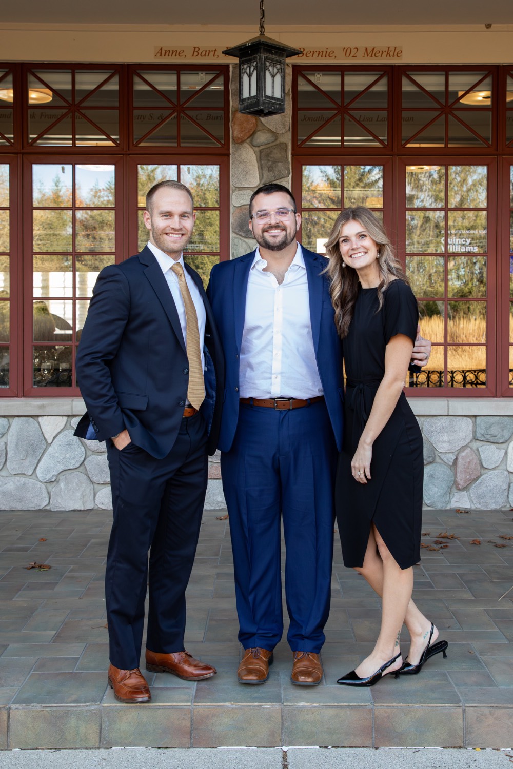 Alex Hogarth poses with 2 other people outside of Alumni House